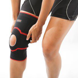 Genouillère sport noire et rouge — anneau rotulien ouvert